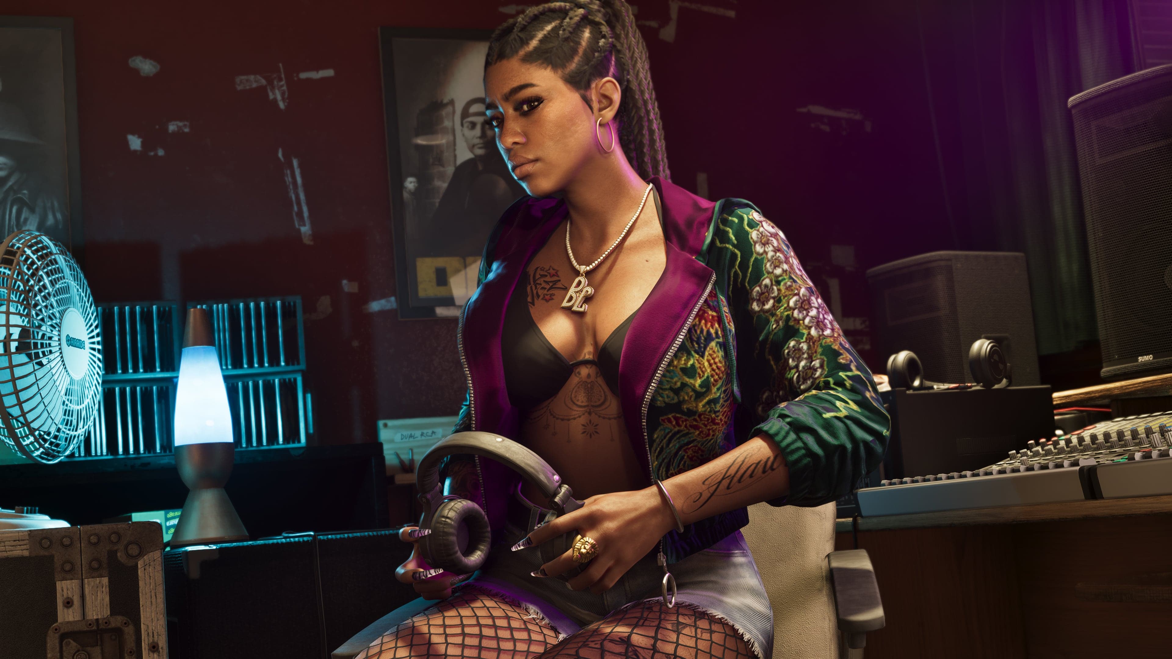 Official Rockstar Games render of Real Dimez — the rap duo Bae-Luxe and Roxy, depicted in a recording studio setting with a lava lamp and mixing console behind them. One member is shown holding headphones, mid-recording.